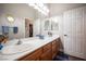 Bathroom with a double sink vanity, a large mirror and wood cabinets at 1901 Shady Elm St, Las Vegas, NV 89135