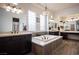 Bright bathroom featuring a soaking tub, dual vanities, wood-look flooring and modern fixtures at 1901 Shady Elm St, Las Vegas, NV 89135