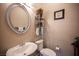 Powder room featuring a pedestal sink, oval mirror, and decorative accents at 1901 Shady Elm St, Las Vegas, NV 89135