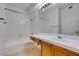 Clean bathroom with tiled tub and shower, wood vanity, and mirror at 2110 Los Feliz St # 1046, Las Vegas, NV 89156