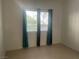 Simple bedroom with teal and black curtains and tile floor at 2110 Los Feliz St # 1046, Las Vegas, NV 89156