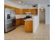 Kitchen with wood cabinets, stainless steel appliances, and tile floor at 2110 Los Feliz St # 1046, Las Vegas, NV 89156