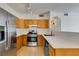 Kitchen with wood cabinets, stainless steel appliances, and tile floor at 2110 Los Feliz St # 1046, Las Vegas, NV 89156