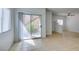 Bright living room with tile floors, sliding door to patio, and access to kitchen at 2110 Los Feliz St # 1046, Las Vegas, NV 89156