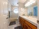 Bathroom with a single sink vanity, shower/tub combo, tile floors, and a decorative window at 2327 River City Dr, Laughlin, NV 89029