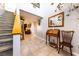 Inviting entryway with staircase, tiled floor, decorative mirror and writing desk creating a warm welcome to the home at 2327 River City Dr, Laughlin, NV 89029
