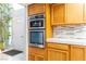 Modern kitchen with built-in oven and microwave, white countertops, stylish backsplash, and bright oak cabinets at 2327 River City Dr, Laughlin, NV 89029