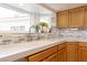 Close-up of a bright kitchen with stainless steel faucet, white countertops, light oak cabinets, and stylish backsplash at 2327 River City Dr, Laughlin, NV 89029