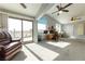 Spacious living room with neutral carpet, vaulted ceilings, ceiling fans, and balcony access at 2327 River City Dr, Laughlin, NV 89029