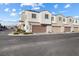 Street view of townhome exterior featuring garages, landscaping, and well-maintained facade at 3558 Herodain Ave, Las Vegas, NV 89106