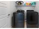 A modern laundry room includes a washer, dryer, and overhead shelving for storage at 3558 Herodain Ave, Las Vegas, NV 89106