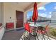 Outdoor patio seating area with red chairs and table with umbrella near front door at 3558 Herodain Ave, Las Vegas, NV 89106