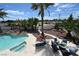 Aerial view of a pool and spa surrounded by palm trees, lounge seating and a beautiful rockscape at 4193 W Warm Springs Rd, Las Vegas, NV 89118