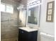Bathroom featuring a shower with glass door, single sink vanity, and neutral wall art at 4193 W Warm Springs Rd, Las Vegas, NV 89118