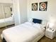 Bedroom featuring a queen bed, mirrored closet, bedside table, and decorative wall art at 4193 W Warm Springs Rd, Las Vegas, NV 89118