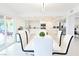 Bright dining room with white table, modern chairs, and open view of a pristine, all-white kitchen at 4193 W Warm Springs Rd, Las Vegas, NV 89118