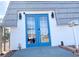 Exterior view of a white building featuring blue double doors and a well-lit entrance at 4193 W Warm Springs Rd, Las Vegas, NV 89118