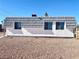 Exterior view of a white building featuring a gray tiled roof and a gravel yard at 4193 W Warm Springs Rd, Las Vegas, NV 89118
