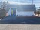 Exterior view of a building featuring blue double doors, a tiled roof and a gravel yard at 4193 W Warm Springs Rd, Las Vegas, NV 89118