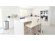 The open-concept kitchen features white cabinets, stainless steel appliances, and a stylish breakfast bar at 4193 W Warm Springs Rd, Las Vegas, NV 89118