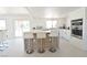 Bright modern kitchen with bar seating, stainless steel appliances, and an open connection to the outdoors at 4193 W Warm Springs Rd, Las Vegas, NV 89118