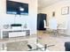 Living room area with a modern tv console and a glass top coffee table with dining area in the background at 4193 W Warm Springs Rd, Las Vegas, NV 89118