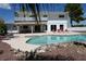 Spacious backyard featuring a sparkling pool, multiple lounge chairs, rock features and mature trees at 4193 W Warm Springs Rd, Las Vegas, NV 89118