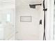 Modern walk-in shower featuring sleek black fixtures, clean white tile, and a built-in niche at 4193 W Warm Springs Rd, Las Vegas, NV 89118