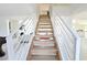Bright, modern staircase with sleek white railings and natural wood steps connecting multiple levels of the home at 4193 W Warm Springs Rd, Las Vegas, NV 89118