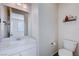 Clean half bathroom with white vanity, toilet, and decorative shelving at 422 Barcarolle Ln, Henderson, NV 89011