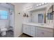 Modern bathroom featuring a dual sink vanity, a large mirror, and a separate toilet and shower area at 422 Barcarolle Ln, Henderson, NV 89011