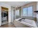 Relaxing bathroom featuring a soaking tub, separate shower, and tiled walls at 422 Barcarolle Ln, Henderson, NV 89011