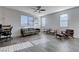 Spacious living room with a modern sofa, stylish chairs, a ceiling fan, and large windows for plenty of light at 422 Barcarolle Ln, Henderson, NV 89011