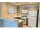 Modern kitchen featuring gray cabinets, white appliances, and a breakfast bar at 5002 S Rainbow Blvd # 106, Las Vegas, NV 89118