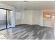 Living room with gray vinyl flooring, access to a balcony, and an open floor plan at 5002 S Rainbow Blvd # 106, Las Vegas, NV 89118