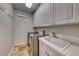 Bright laundry room with washer, dryer, cabinets and a utility sink at 61 Contrada Fiore Dr, Henderson, NV 89011