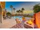 Inviting backyard with a fire pit, pool, spa and palm trees at 61 Contrada Fiore Dr, Henderson, NV 89011