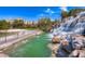 Resort-style waterfall and pond feature with a sandy beach area at 61 Contrada Fiore Dr, Henderson, NV 89011