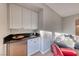 Convenient wet bar with granite countertop and white cabinetry at 61 Contrada Fiore Dr, Henderson, NV 89011