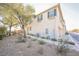 Tan two-story townhome with attached garage and landscaped yard at 7332 Marble Lake St # 103, Las Vegas, NV 89149