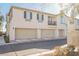 Rear view of townhome showing attached garages and a balcony at 7332 Marble Lake St # 103, Las Vegas, NV 89149