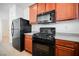 Modern kitchen with black appliances and wood cabinets at 7332 Marble Lake St # 103, Las Vegas, NV 89149