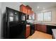 Kitchen with wood cabinets, black appliances, and tile floor at 7332 Marble Lake St # 103, Las Vegas, NV 89149