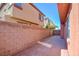 Long and narrow patio area with brick wall and adjacent home at 8557 Nature Scene Dr, Las Vegas, NV 89139