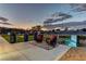 Serene backyard at dusk with comfortable seating, ambient lighting, and a beautifully landscaped garden at 8880 W Ann Rd, Las Vegas, NV 89149