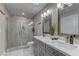 Bathroom features a glass-enclosed shower, double vanity, tiled floors and walls, and soft lighting at 8880 W Ann Rd, Las Vegas, NV 89149