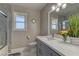 Bathroom with gray cabinets, a large mirror, and a shower with decorative tile at 8880 W Ann Rd, Las Vegas, NV 89149