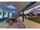 Covered patio with modern table and seating, offering a view of the expansive, beautifully landscaped backyard at 8880 W Ann Rd, Las Vegas, NV 89149