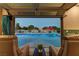 Relaxing seating area inside a pool house offers a view of the sparkling blue pool and backyard at 8880 W Ann Rd, Las Vegas, NV 89149