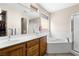 Bright bathroom featuring double sinks, large mirror and soaking tub with shower at 1428 Chaparral Dr, Mesquite, NV 89027